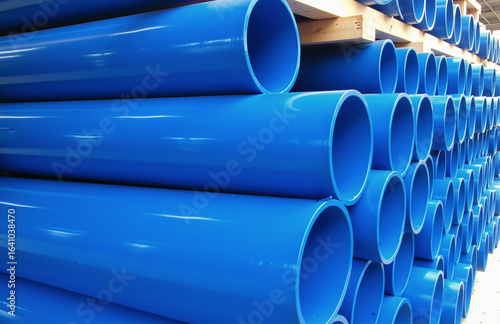 Neatly stacked blue PVC pipes in wooden frame