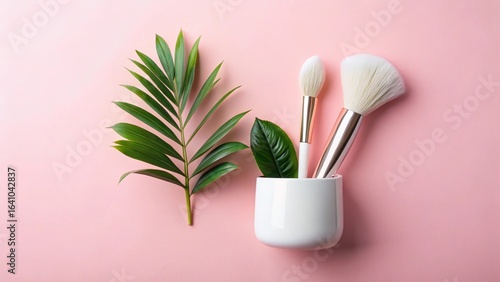 A cosmetic brush with pink petals and a black stick lies on a white background, perfect for a spa still life