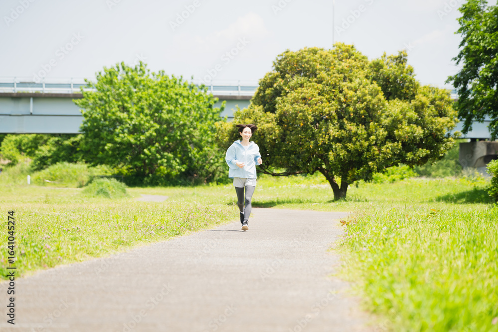 Obraz premium ランニングをする若い女性 スポーツイメージ