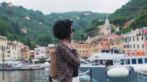 Stylish fashionable woman gazes at the beautiful town of Portofino, Italy