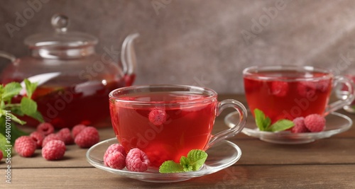 Wallpaper Mural Tasty raspberry tea in glass cups, teapot, berries and mint on wooden table, closeup Torontodigital.ca
