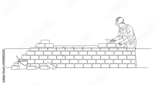 Skilled bricklayer in hard hat meticulously laying bricks with trowel and mortar