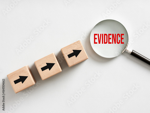 Magnifying glass showing evidence and wooden cubes with arrows pointing towards it