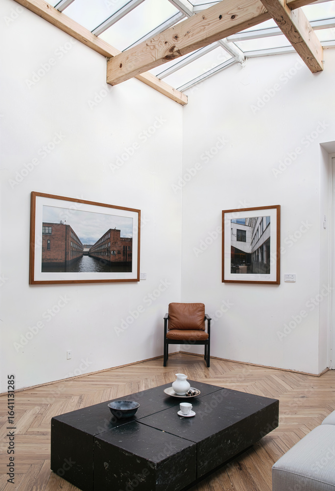 Fototapeta premium A bright and minimalist art gallery interior featuring a high vaulted ceiling, white walls, and framed artwork for a serene and contemplative viewing experience. 