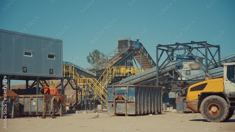 Outdoor construction waste sorting line at an industrial recycling facility on a sunny day Outdoor construction waste sorting line at an industrial recycling facility on a sunny day