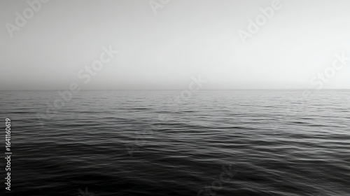 A minimalist black and white photo of a calm sea with a smooth horizon under a clear sky.