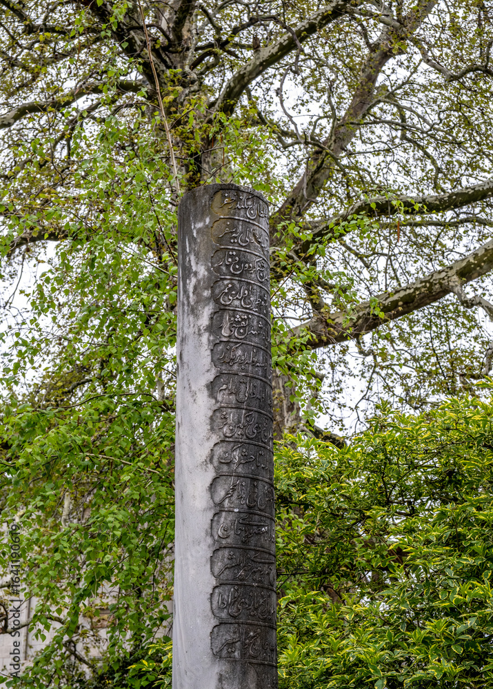 Fototapeta premium An ancient stone pillar with Arabic script and inscriptions.