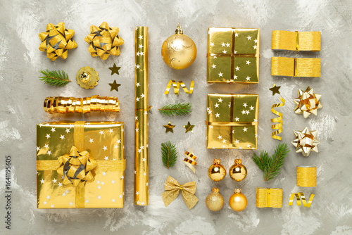 Handmade wrapped christmas gift boxes with stuff on concrete background, top view