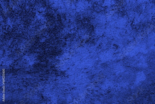 Close-up view of a blue textured wall showing rough patterns and intricate shadow details, offering a visually appealing background texture for versatile creative uses.