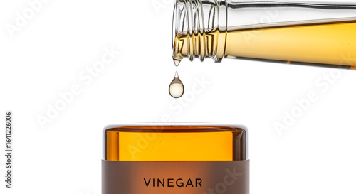 Apple cider vinegar pouring from bottle into jar for health and wellness concept and cooking ingredient