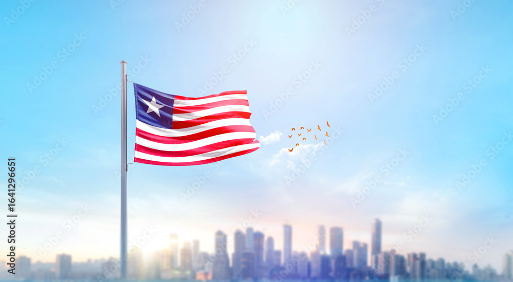 Fototapeta premium Liberia national flag waving with skyline and buildings. Liberia national flag for independence day.
