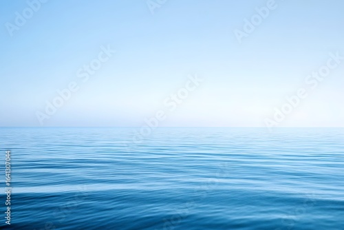 Empty ocean scene with gradient blue sky, very calm water, flat horizon background