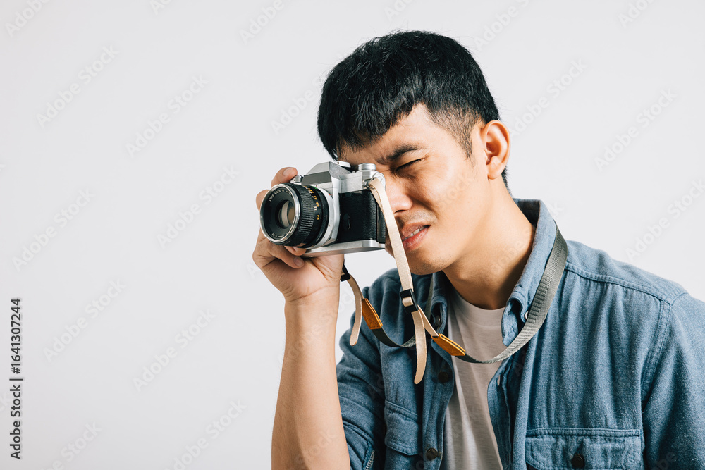 Portrait of a happy young man ready for his close-up with a vintage camera. Studio shot isolated on white background. This snapshot oozes glamour and film-inspired style. Portrait of a happy young man ready for his close-up with a vintage camera. Studio shot isolated on white background. This snapshot oozes glamour and film-inspired style.