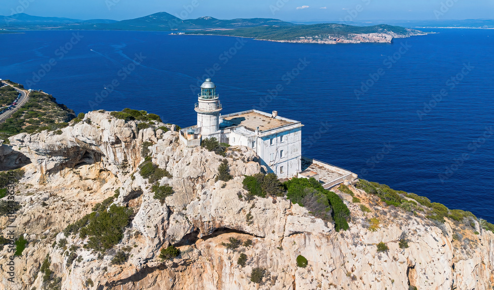 Aerial view of the lighthouse of Cape Caccia, an imposing limestone promontory overlooking the Mediterranean Sea west of Alghero in the northwestern tip of Sardinia, Italy Aerial view of the lighthouse of Cape Caccia, an imposing limestone promontory overlooking the Mediterranean Sea west of Alghero in the northwestern tip of Sardinia, Italy