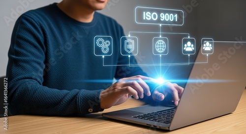 Man using laptop with virtual diagram of quality control ISO 9001 certification standards