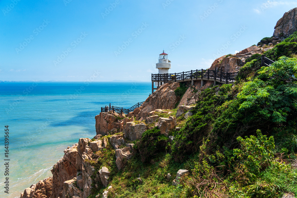 Fototapeta premium Tranquil Coastal Scene Featuring a Majestic Lighthouse by the Sea