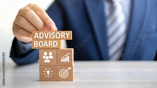 Businessman holding wooden block with advisory board text and business strategy icons representing corporate governance and leadership 
