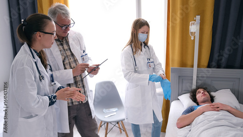 Fotografia The doctor, the resident and the intern examine the young patient