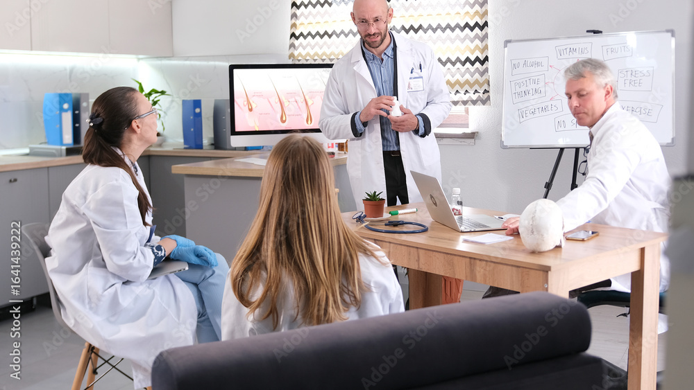 Obraz premium The laboratory's researchers are discussing a new treatment system for hair loss. A group of doctors is sitting at a table in the clinic's meeting room