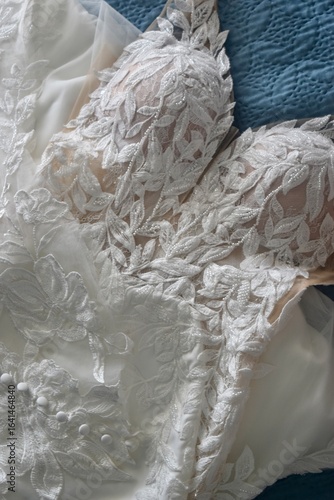 White wedding dress with lace and beading closeup against blue background