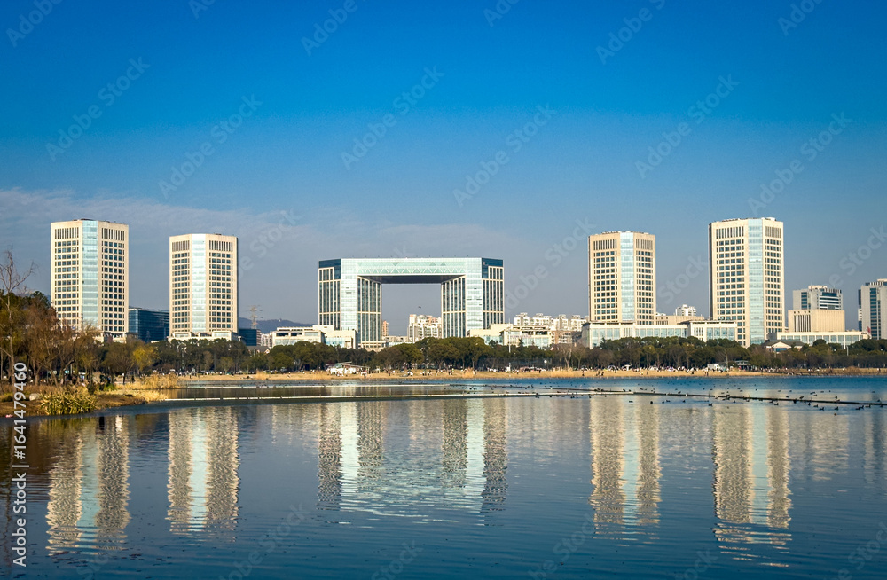 Fototapeta premium Urban Reflections: Modern Architecture Mirrored in Tranquil Waters