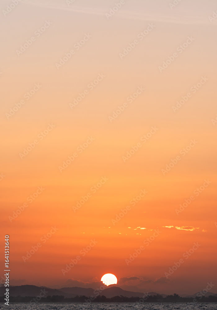 Sun dawn vertical over sea mountaint in the evening, Orange sunset and red sun light golden hour sky cloud background, Horizon dusk sea landscape summer Sun dawn vertical over sea mountaint in the evening, Orange sunset and red sun light golden hour sky cloud background, Horizon dusk sea landscape summer