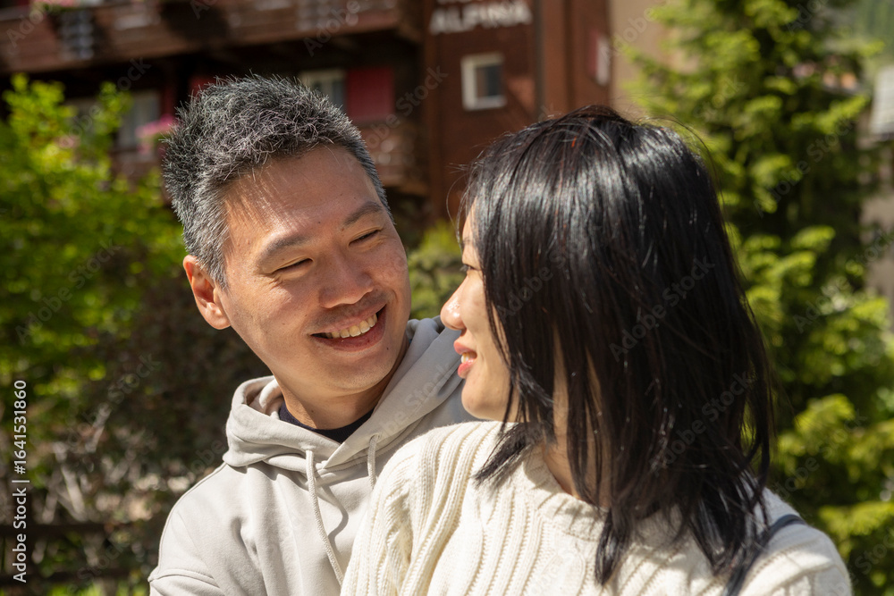 Fototapeta premium Asian couple sharing a tender moment outdoors in the mountains