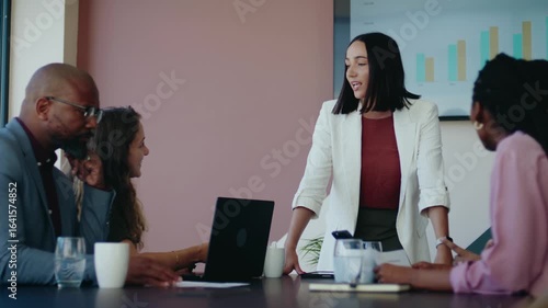 Young businesswoman giving presentation to diverse team in boardroom of office during daytime