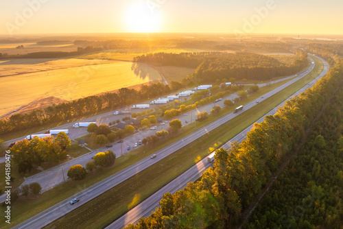 Big parking truck stop for tractor trailers rest area near busy American highway. Hauling cargo concept