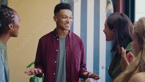 Group of diverse coworkers applauding businessman in office space during daytime