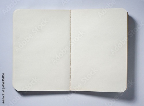 Fotografie Opened empty book with white plain paper isolated on horizontal copy spaced white background from top angle view