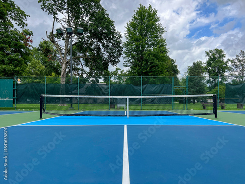 Wallpaper Mural Outdoor Pickleball Courts. Centerline view of pickle ball courts, looking towards the net. Public city park setting with cloudy blue Summer sky. Torontodigital.ca