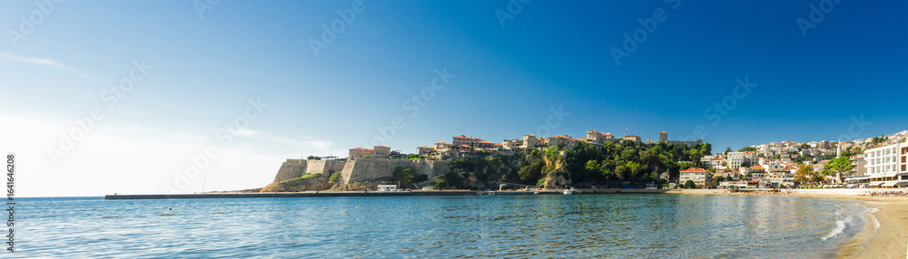 View of Ulcinj’s Old Town and sandy beach along the Adriatic coast, showcasing medieval fortress walls, hillside houses, and a bright summer seascape. View of Ulcinj’s Old Town and sandy beach along the Adriatic coast, showcasing medieval fortress walls, hillside houses, and a bright summer seascape.