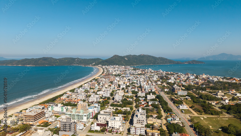 Fototapeta premium Aerial view of Mariscal and Canto Grande beaches with clear waters and coastal city, Santa Catarina, Brazil.