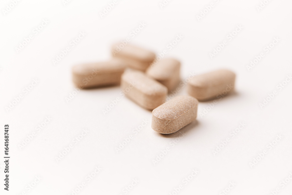 Lion’s mane mushrooms tablets that have beneficial effects on the body, especially the brain, heart, and intestines. Bright paper background. Soft focus. Close up. Copy space. Lion’s mane mushrooms tablets that have beneficial effects on the body, especially the brain, heart, and intestines. Bright paper background. Soft focus. Close up. Copy space.