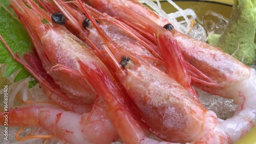 Close up of fresh raw shrimp served on a plate with garnish and ice