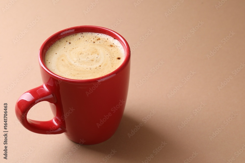 Obraz premium Aromatic coffee in cup on beige background, closeup. Space for text