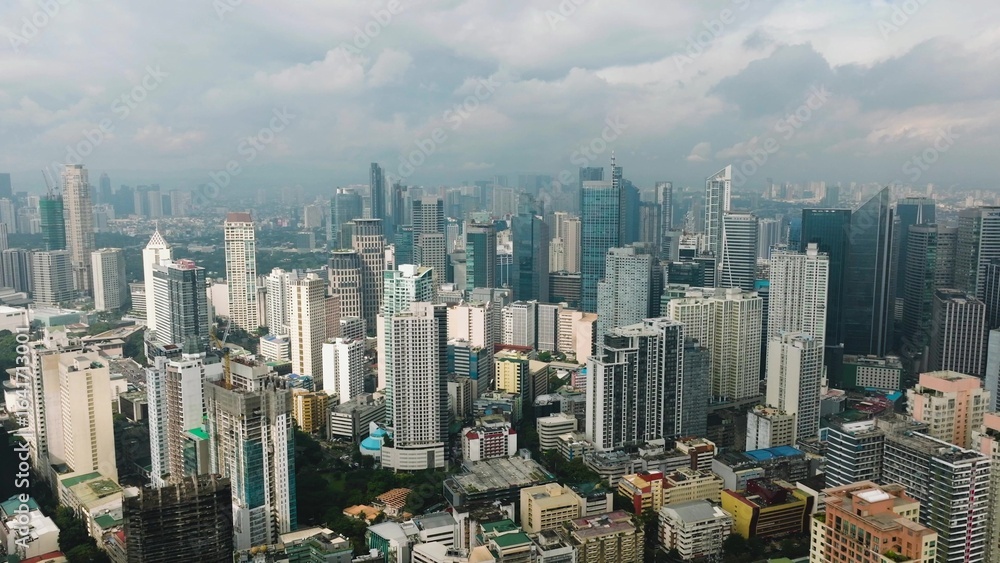 Obraz premium View of high rise buildings in a dense modern city with clear skies and urban vibrancy. Metro Manila, Philippines.
