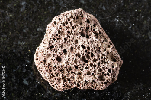 Fotografija sample of rough brown pumice mineral on black