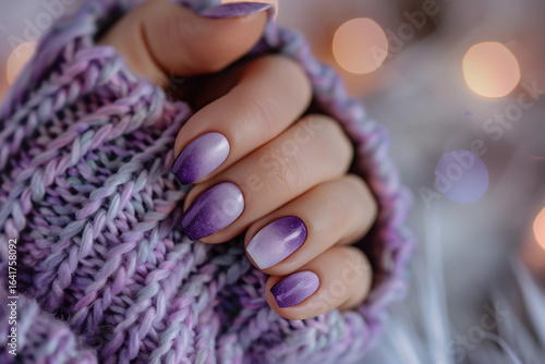 Closeup of female hands with purple ombre manicure and wool sweater