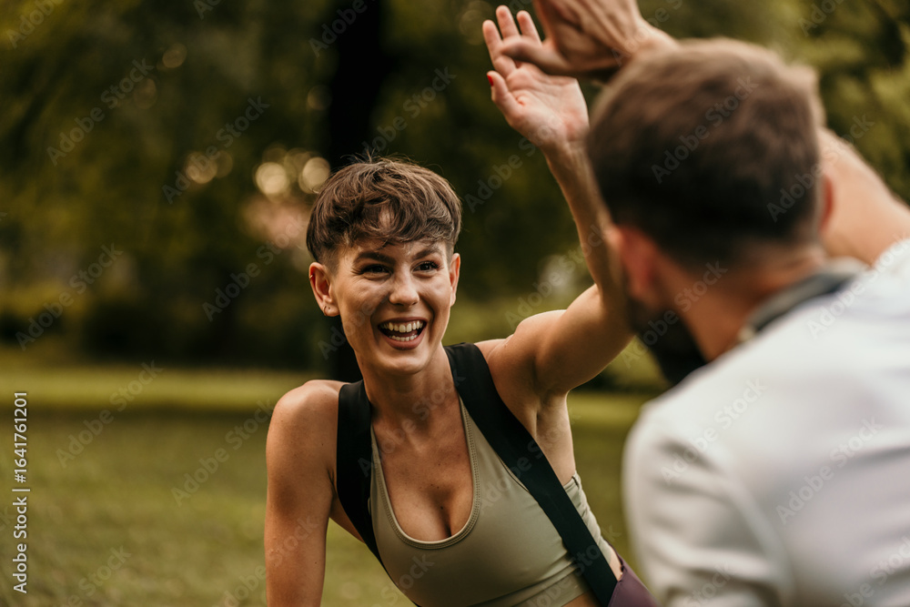 Happy fitness couple giving high five after training outdoors Happy fitness couple giving high five after training outdoors