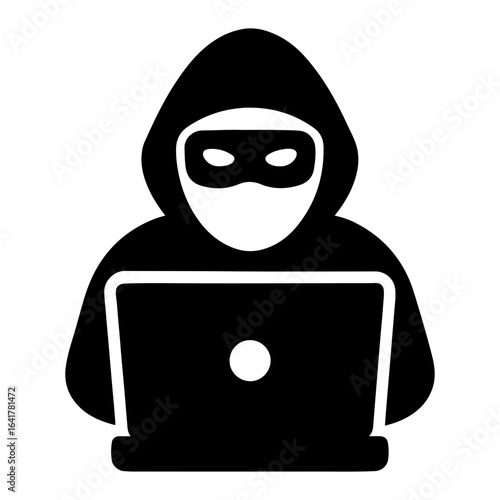 Silhouette of a hacker using a laptop computer to commit cyber crime and data theft online while remaining anonymous