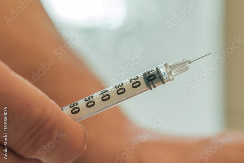 Patient holds syringe and prepares to inject glp-1 medication
