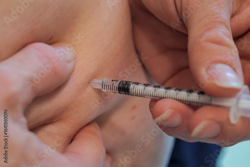 Patient holds syringe and injects glp-1 medication into belly