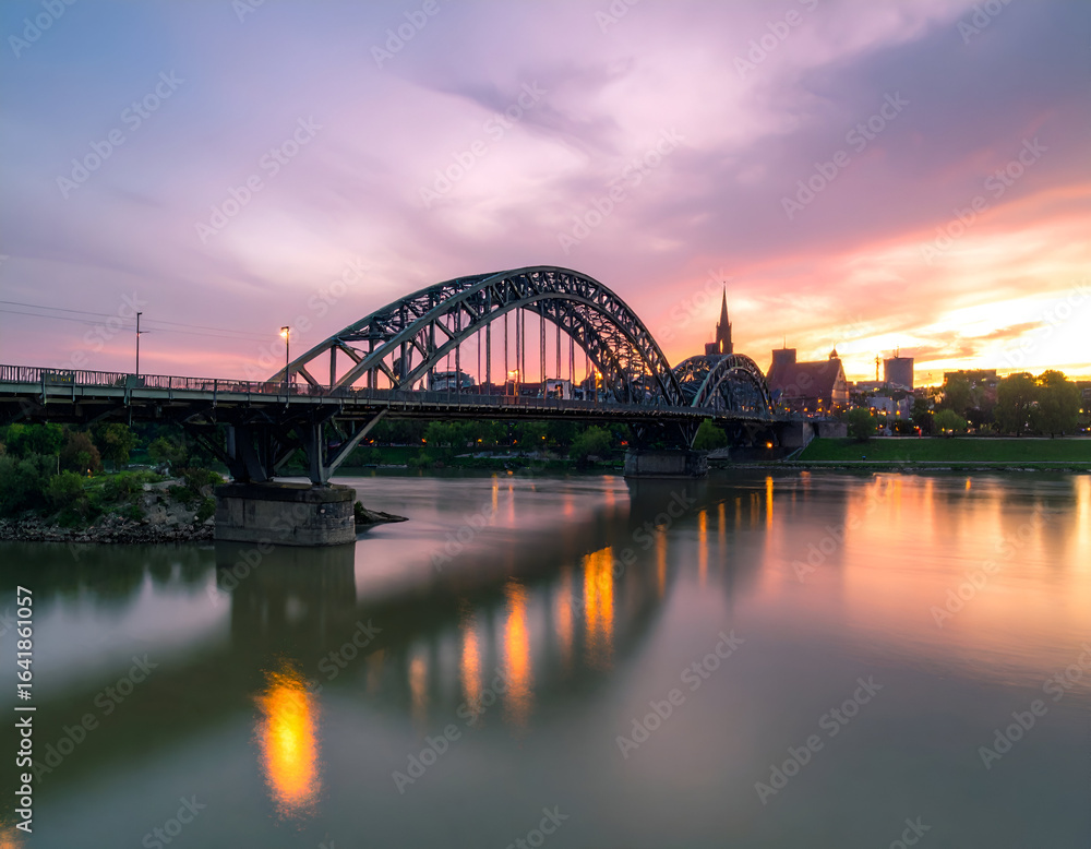Fototapeta premium Steel Bridge at Sunset Over City River Reflection