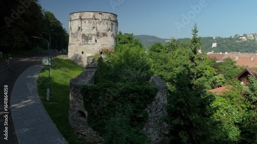 Aerial summer morning view over Brasov medieval fortifications, showcasing Bastionul Postavarilor, Turnul Lemnarului, Turnul Vanatorilor and Bastionul Funarilor alongside the old town center
