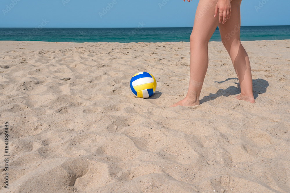 Obraz premium Woman getting ready to pick volleyball on the beach