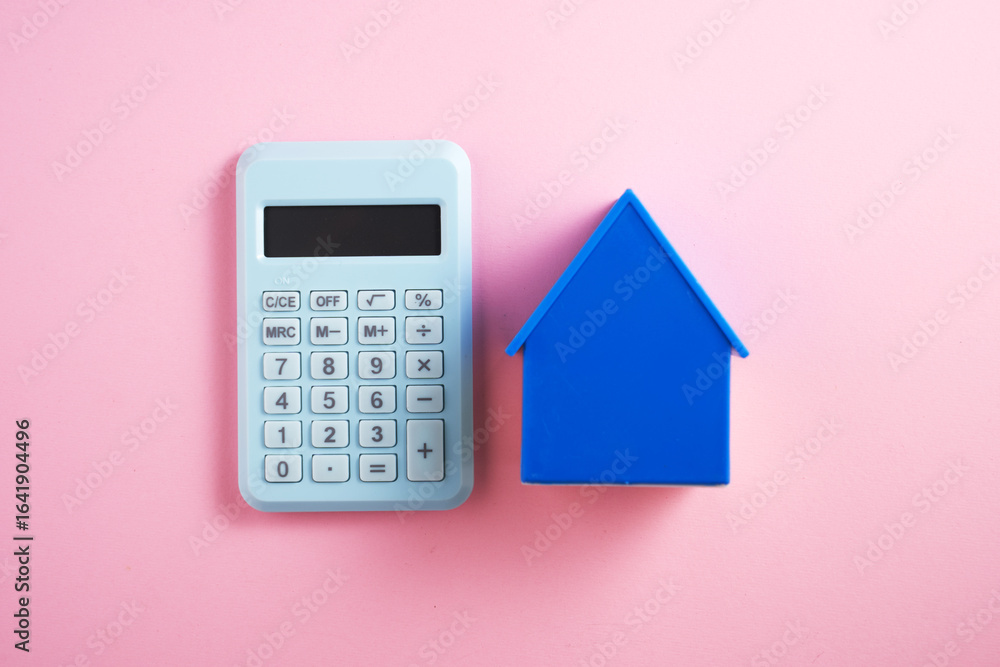 blue model house and a white calculator. blue model house and a white calculator.