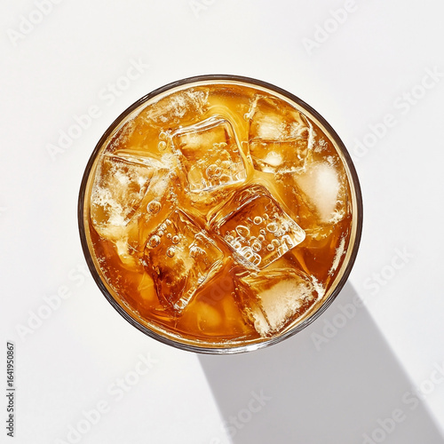 Overhead view of amber iced tea in a clear glass with ice cubes amber liquid refreshing