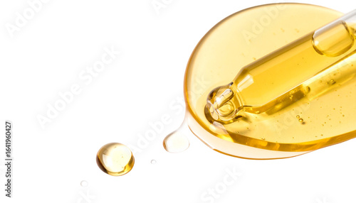 Golden serum droplet from dropper on sleek black background